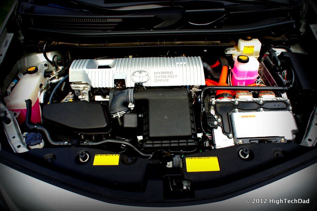 The engine bay of a hybrid car with orange high-voltage cables visible