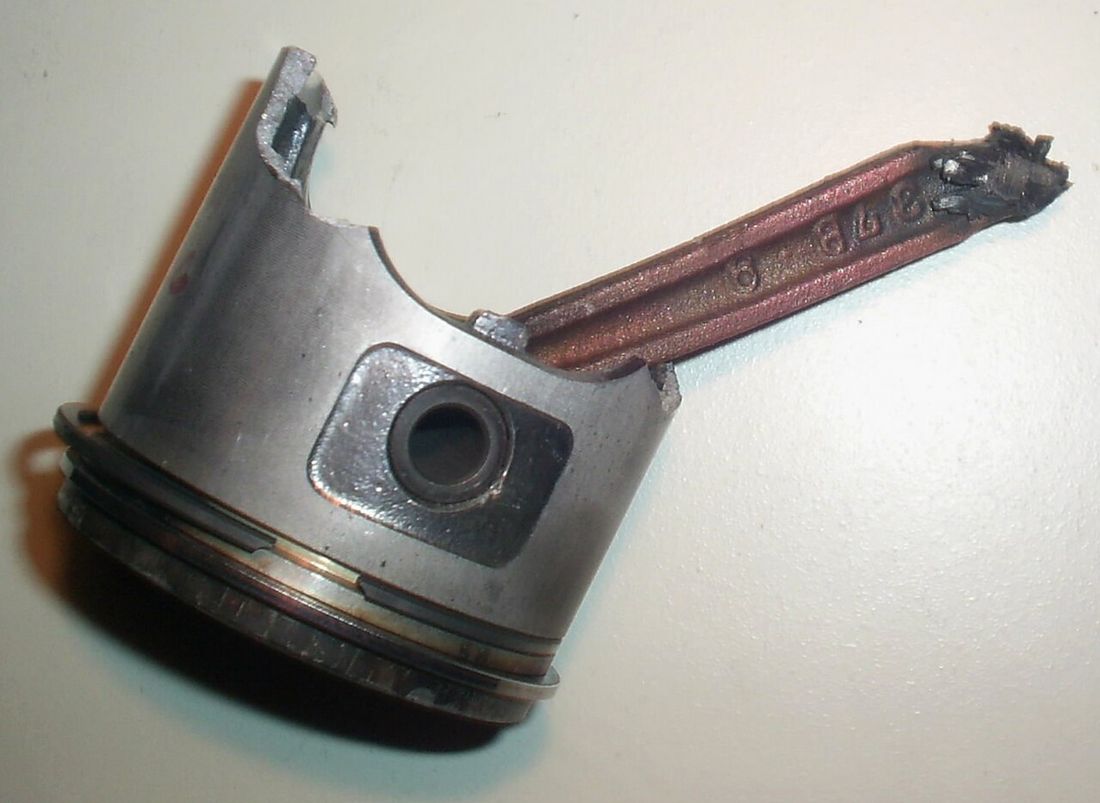 A damaged piston and bent connecting rod removed from an engine